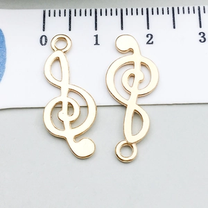 Vue macro de pendentifs clé de sol dorés de 2,5 cm avec règle graduée de référence
