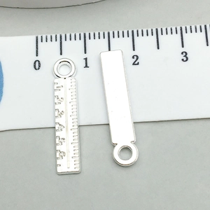 Dettaglio macro di ciondoli a righello in metallo con scala per creazione gioielli fai da te