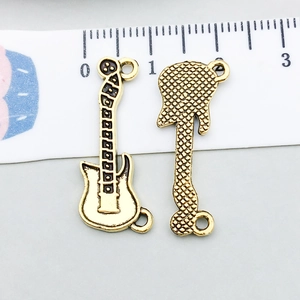 Détail d'un pendentif guitare doré montrant la texture quadrillée au verso du bijou