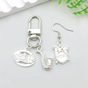 Detail view of silver music-themed charms featuring saxophone, notes, and drum kit set