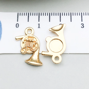 Vue détaillée d'un pendentif cor d'harmonie doré avec échelle de mesure pour bijoux
