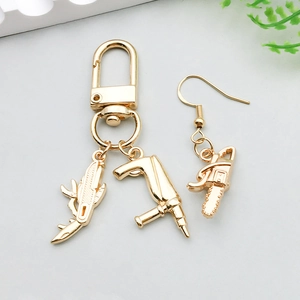Detailaufnahme goldener Werkzeug-Anhänger wie Kettensäge und Bohrer für DIY-Schmuck