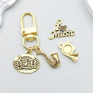 Ensemble détaillé de pendentifs musicaux dorés avec saxophone, cor et notes de musique