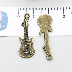 Dettaglio del ciondolo a forma di chitarra elettrica bronzo con trama fronte e retro