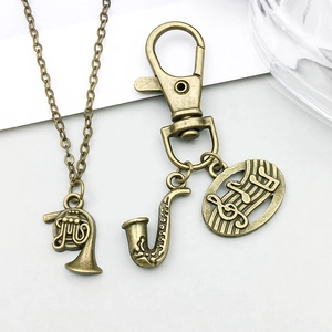 Dettaglio di ciondoli musicali in bronzo antico con corno e sassofono in stile vintage