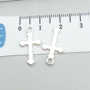 Dettaglio del ciondolo a croce d'argento con righello che mostra le dimensioni reali