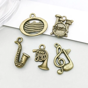 Dettaglio di ciondoli a forma di strumenti musicali in bronzo per gioielli DIY