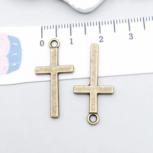 Close-up of two bronze hollow cross pendants with fine texture for DIY jewelry making