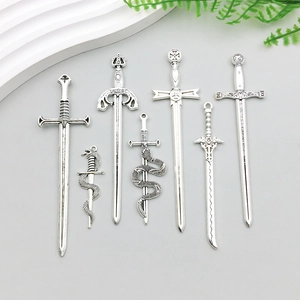 Detailed view of seven assorted vintage silver alloy sword charms for DIY jewelry making