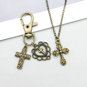 Macro shot of vintage bronze alloy hollow cross pendants and heart charms on chains