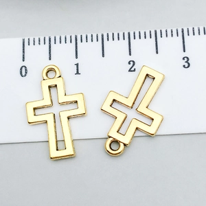 Detail of hollow gold cross pendants for DIY jewelry with ruler scale measurement