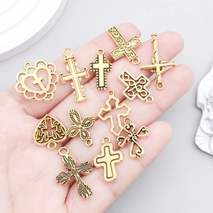 Antique gold hollow cross charms for DIY jewelry making held in hand for scale