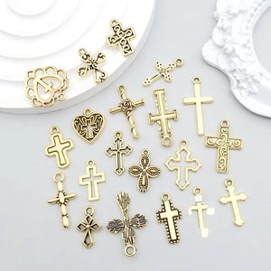 Detailed flat lay of assorted gold alloy hollow cross and heart pendants for DIY jewelry making