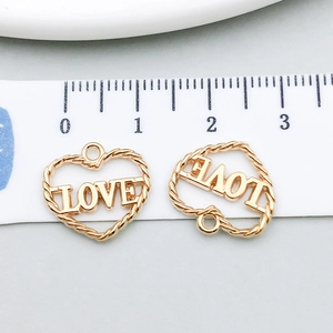 Macro detail of gold love heart pendant showing twisted rope texture and 1.5cm measurement