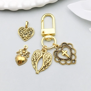 Détail de pendentifs en alliage doré avec cœur et ailes sur un porte-clés mousqueton