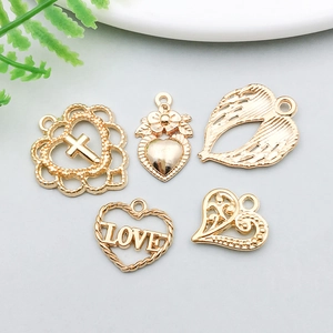 Detailed macro shot of golden alloy heart and wing pendants for DIY jewelry making