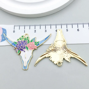 Detail of colorful enamel bull skull pendant with floral patterns and measurement scale