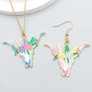 Detail of bohemian cow skull pendants with colorful enamel flowers on gray backdrop