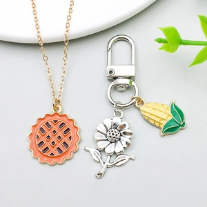Détail de breloques série dinde avec collier floral et pendentif porte-clés en maïs