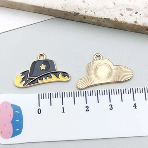 Detail of enamel cowboy hat charm with yellow star and textured metal back for DIY jewelry