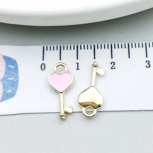 Macro detail of pink enamel heart key pendants measured with a centimeter scale