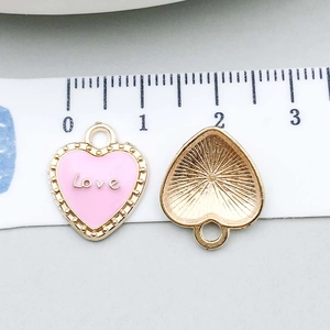 Macro view of pink enamel heart charm with Love engraving showing size 18mm
