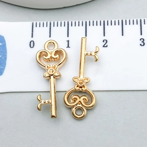 Detail van twee vintage gouden hart-sleutelhangers met liniaal voor de 2,2 cm schaal