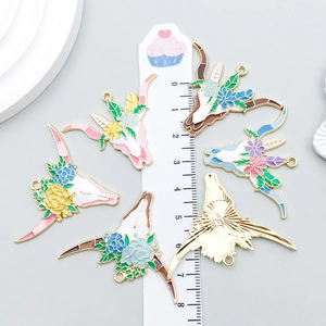 Set of 6 colorful enamel cow skull charms with floral patterns and polished gold finish