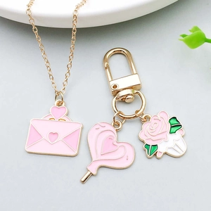 Pink enamel heart-shaped lollipop and envelope pendant jewelry set with golden finish