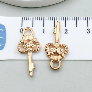 Detailweergave van twee goudkleurige hartvormige sleutelhangers met liniaal van 2 cm