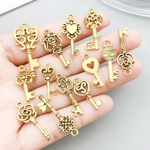 Set of vintage heart and flower key pendants in antique gold finish held in hand