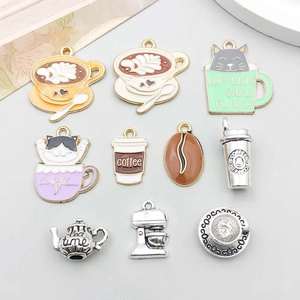 Flat lay of colorful enamel coffee cups and vintage silver tea charms for DIY jewelry making