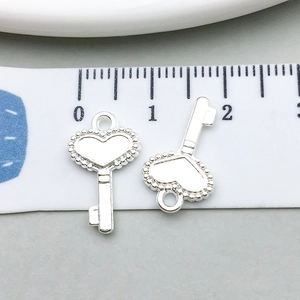 Détail d'un pendentif clé en forme de cœur argenté de 21mm pour la création de bijoux