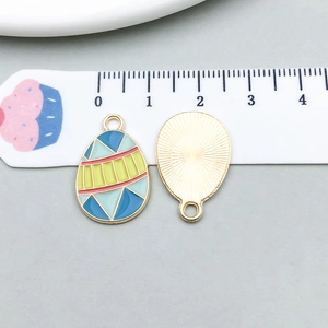Macro detail of enamel Easter egg charms with geometric patterns and size scale
