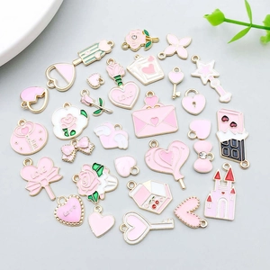 Macro view of pink enamel heart and flower pendants for DIY jewelry making and crafts