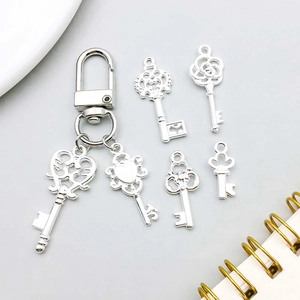 Gros plan de pendentifs clés vintage en argent avec cœur et couronne pour bijoux DIY