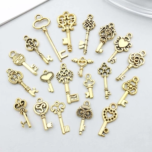 Flat lay of vintage gold alloy key charms with various heart and owl patterns