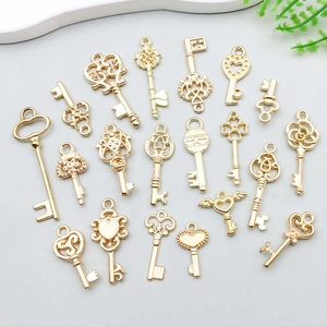 Detailopname van diverse goudkleurige hart- en kroonhangers voor het maken van DIY-sieraden