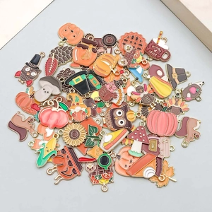 Macro view of assorted autumn enamel pendants including pumpkins, owls, and maple leaves