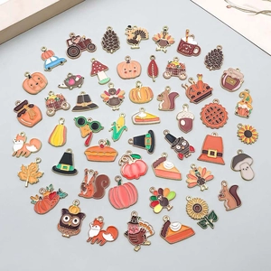 Macro detail of assorted enamel Thanksgiving pendants including pumpkin, turkey and maple leaves