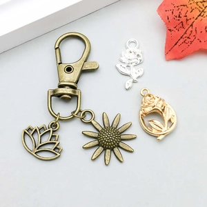 Detail of alloy flower pendants featuring sunflower and rose charms for DIY jewelry making