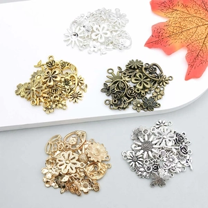 Detailed macro view of assorted alloy flower pendants in various metallic finishes and styles