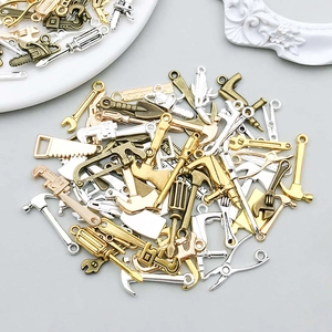 Gros plan de pendentifs mini outils en alliage pour la création de bijoux DIY