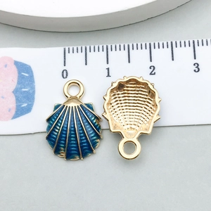 Gros plan d'un pendentif festonné bleu montrant les dimensions avec un ruban à mesurer