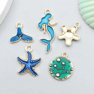 Détail de breloques émaillées DIY thème océan avec sirène et étoile de mer bleue