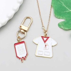 Macro detail of red medical blood bag and white nurse uniform pendants with gold chains