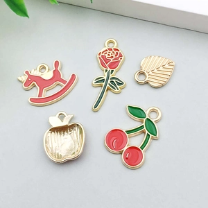 Detail of diverse alloy charms including red rose, unicorn, and cherry for DIY jewelry