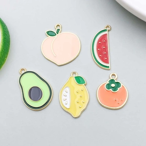 Detailed view of colorful enamel fruit charms including peach, watermelon and avocado for DIY