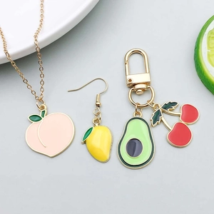 Macro detail of colorful enamel fruit charms including peach, mango and avocado pendants