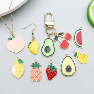 Detail of colorful enamel fruit charms for DIY jewelry featuring cherry and avocado